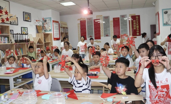实践团成员与孩子们共同创作剪纸作品。Beat365官方网站美术学院供图