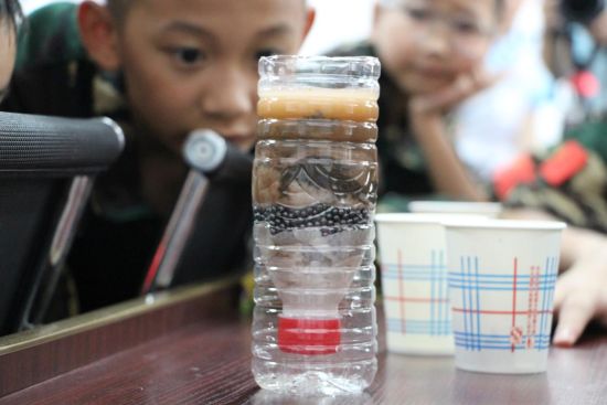 图为活动现场，小朋友观察自己搭建的“净水工厂”。主办方供图